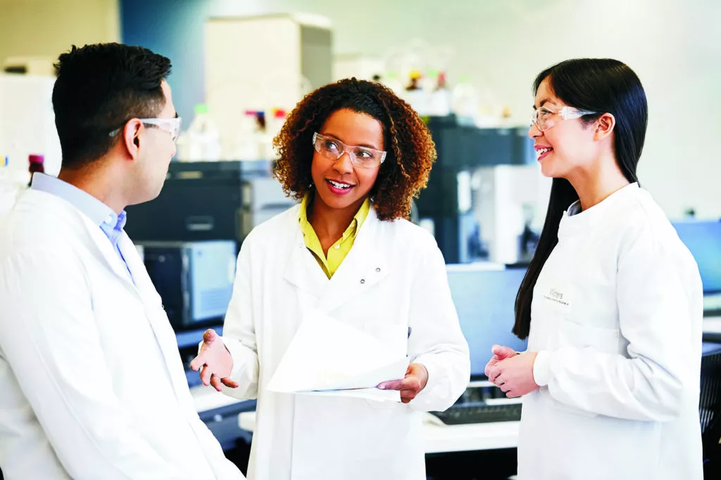 two women in lab coats speaking