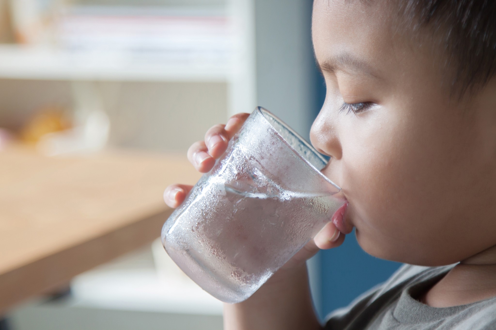 Kind trinkt Wasser aus einem Glas