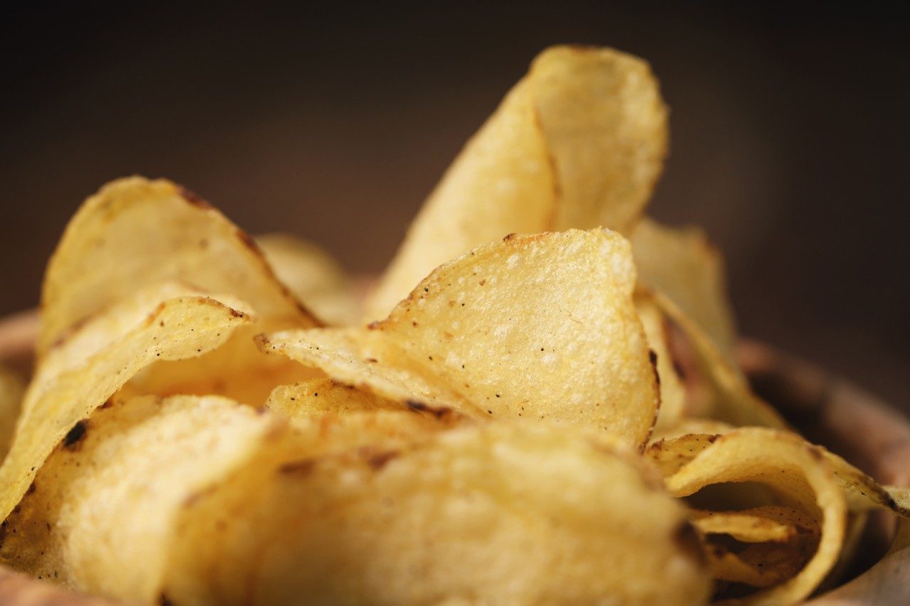 Potato chips in wood bowl on table