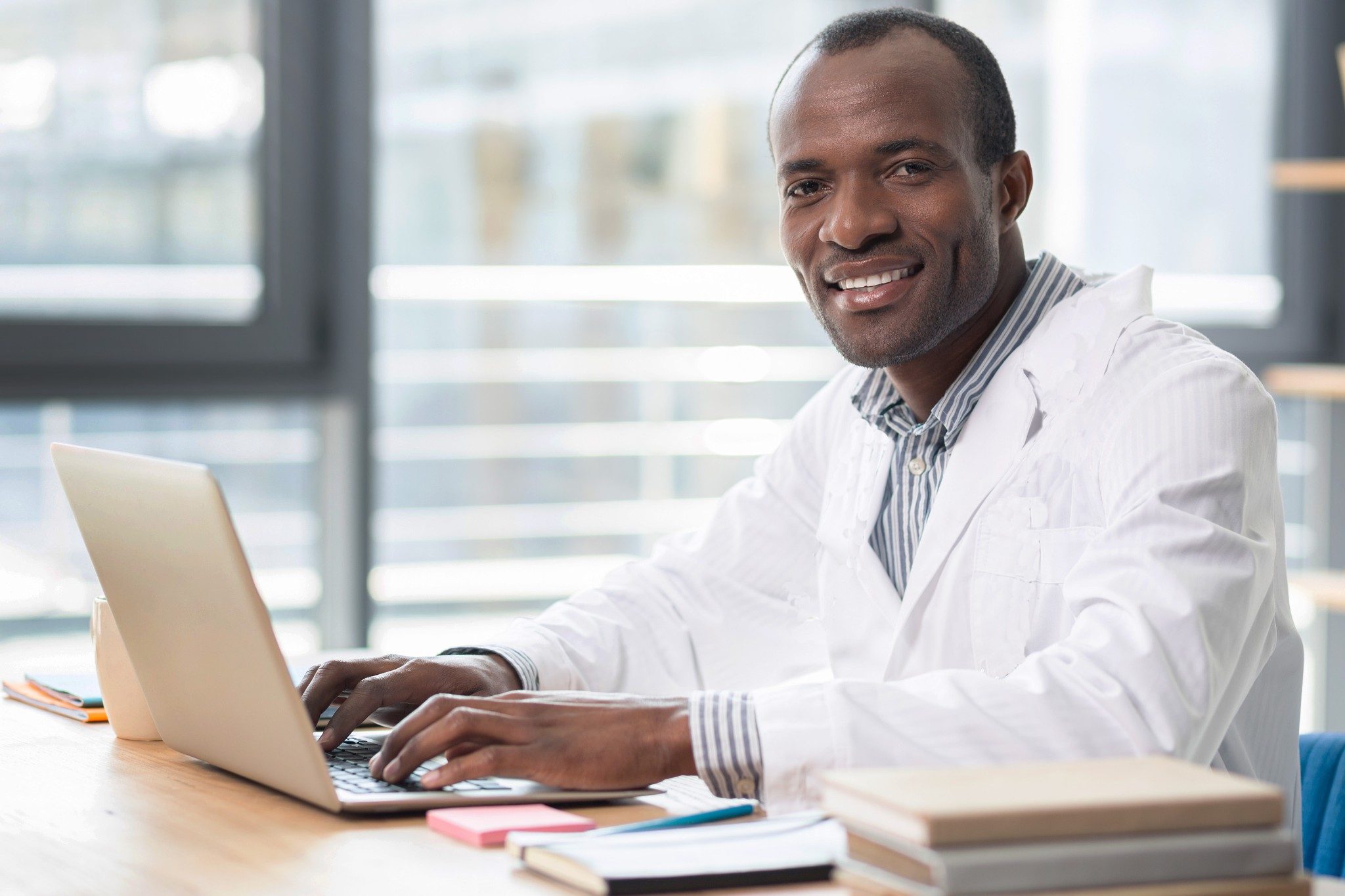 Cientista masculino sorrindo enquanto no computador